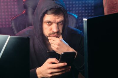 Personne consultant un smartphone, illustration du risque d appel et de SMS frauduleux